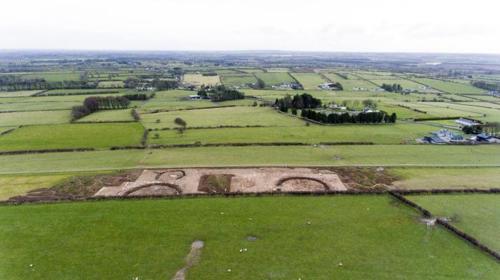 Aerial view of Carroweighter 1–4 under excavation in the middle foreground, with the Oran ecclesiastical site (enclosed by a line of mature trees) at top right (looking south) (Photo: IAC Archaeology).