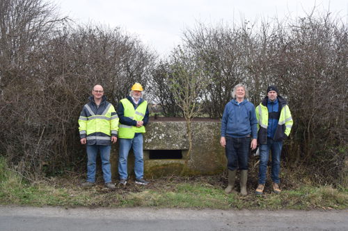 Illustration 12: Paul O’Keeffe (TII Project Archaeologist), Tom Cassidy (Buildings Archaeologist, Fola Heritage Services), Liam Dillon (landowner) and Ed Lyne (LCCC Resident Archaeologist) at a roadside pillbox (PB21) in Coolrahnee (Photo: TII)