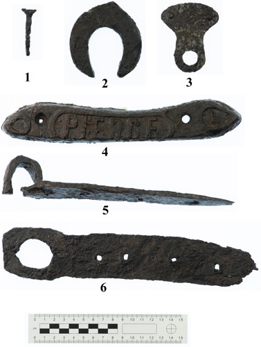 Illus. 8: Examples of iron objects from Clenor South. 1: Horseshoe nail. 2: Possible 17th-century style proto horseshoe or uncompleted trial piece. 3: Peltate (shield-shaped) object; probably a fitting for a handle on a vessel such as a cauldron. 4: Plaque bearing the name Pierce. The Pierce Foundry, founded in Wexford in 1839, manufactured horse-drawn farming vehicles, which were shipped worldwide. 5: Door hinge fragment. 6: Nail maker. The nails were driven through the various-sized holes in the flat plate, which, in this case, had a convenient loop allowing it to be hung on the wall of the forge when not in use (Photo: Dylan Duane Roche).